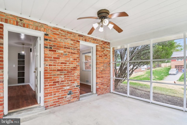 unfurnished sunroom featuring a ceiling fan