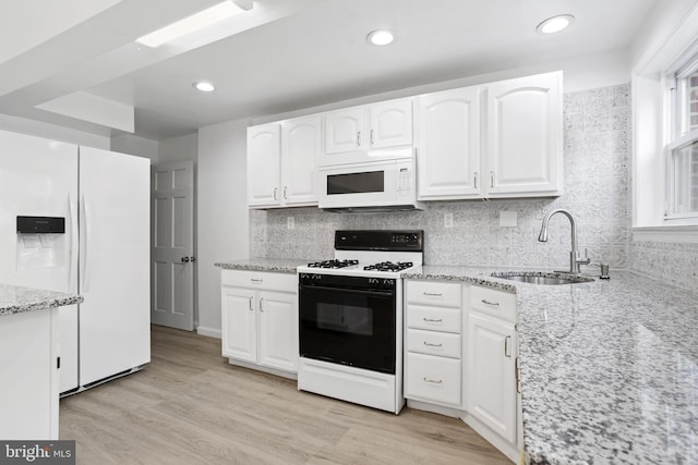 kitchen featuring white cabinetry, sink, white appliances, and light stone counters