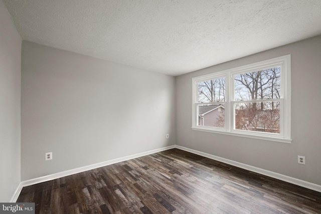 empty room featuring dark hardwood / wood-style flooring and a textured ceiling