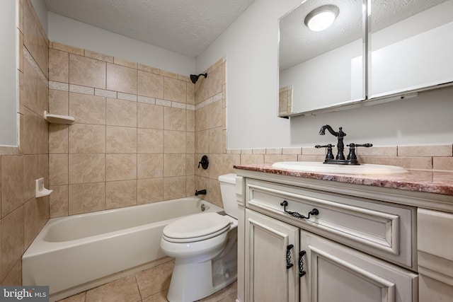 full bathroom featuring tiled shower / bath, vanity, toilet, tile patterned floors, and a textured ceiling