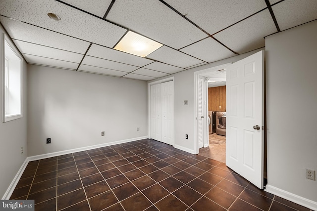 tiled spare room featuring washer / dryer and a paneled ceiling