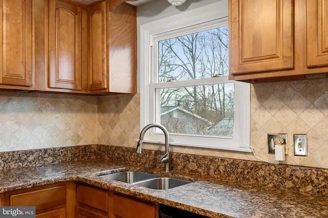 kitchen with tasteful backsplash, sink, and dark stone counters