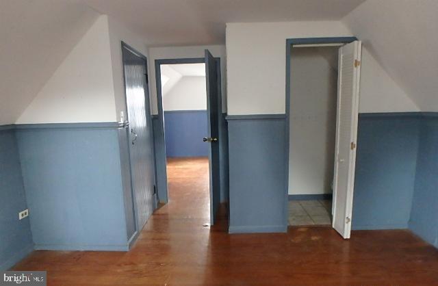 hall featuring lofted ceiling and dark hardwood / wood-style flooring