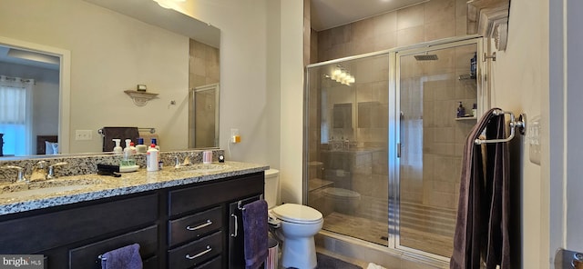 bathroom with a shower with door, vanity, and toilet