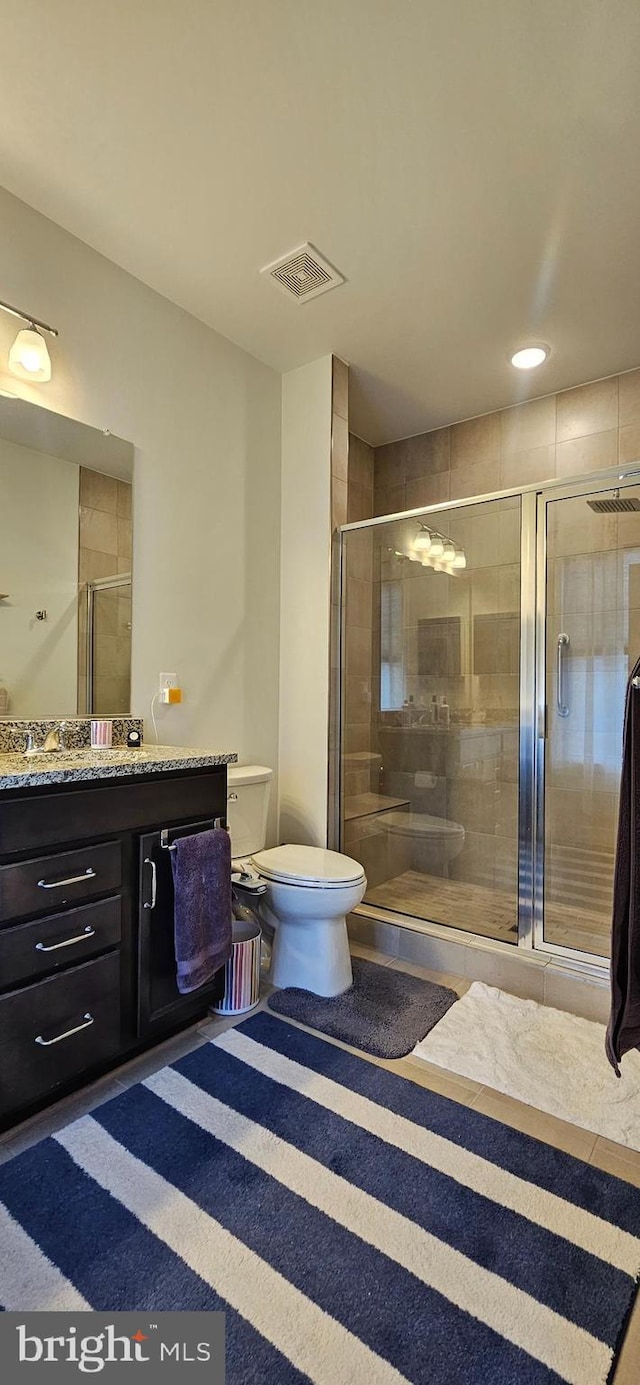 bathroom featuring walk in shower, vanity, and toilet