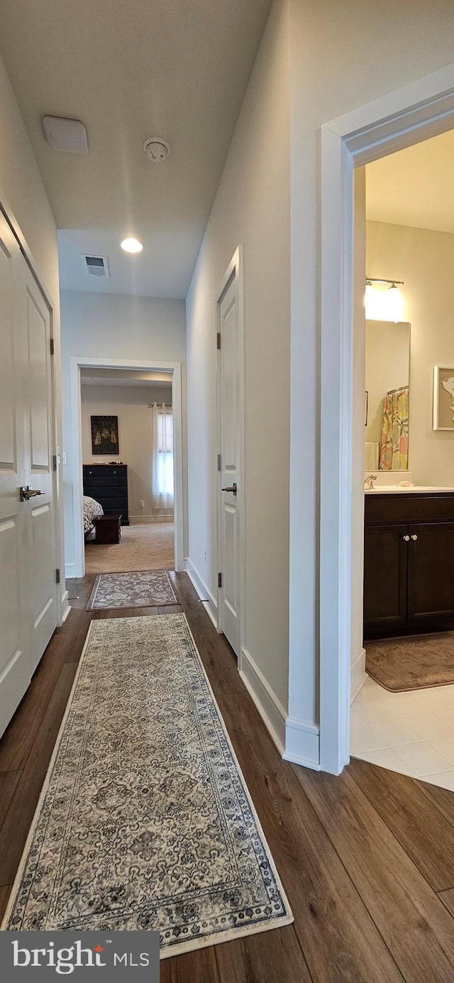 hallway with hardwood / wood-style flooring