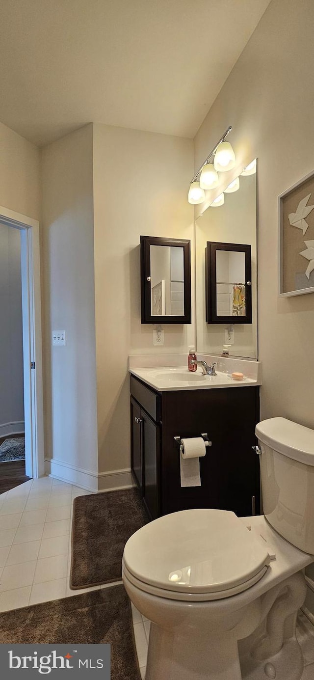 bathroom featuring vanity, tile patterned floors, and toilet