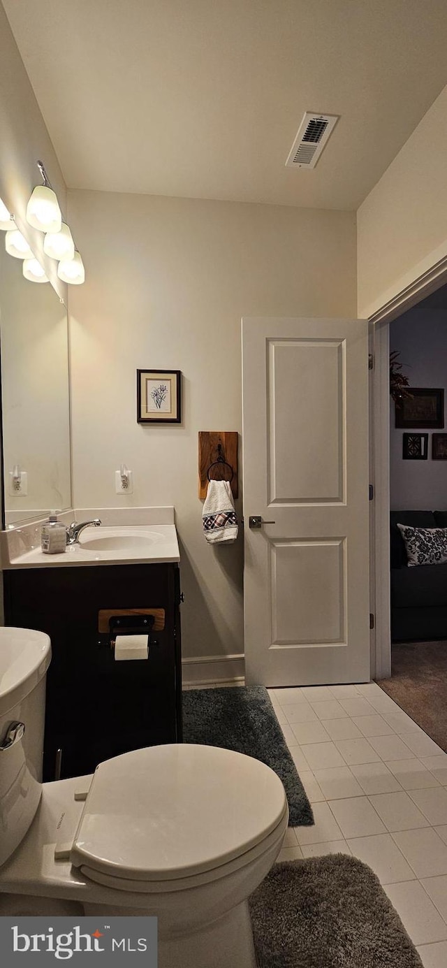 bathroom featuring tile patterned floors, vanity, and toilet