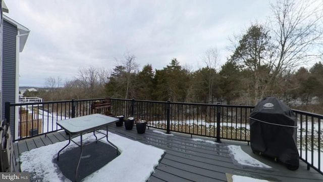 snow covered deck with a grill