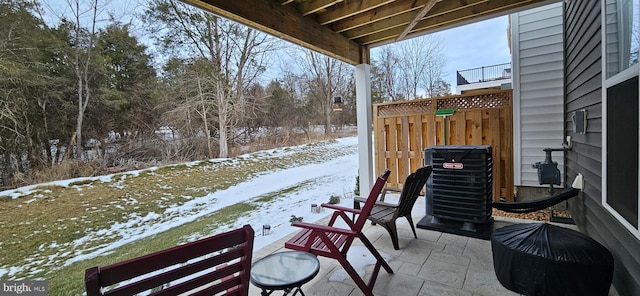 snow covered patio with central AC unit