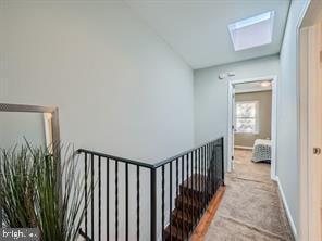 hall with carpet flooring and a skylight