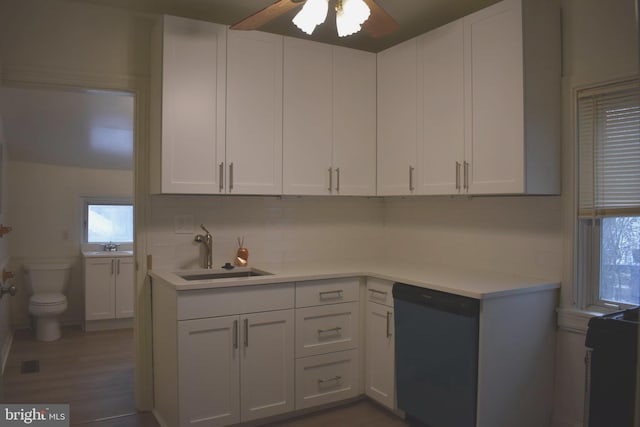 kitchen with backsplash, dishwasher, sink, and white cabinets