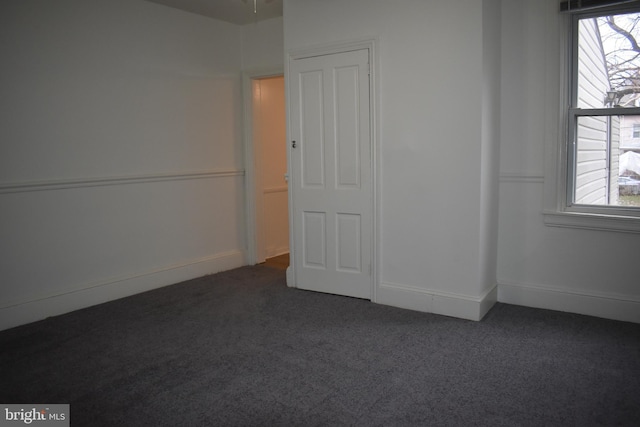 unfurnished bedroom with dark colored carpet