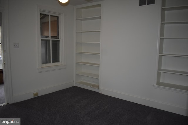 carpeted empty room with built in features