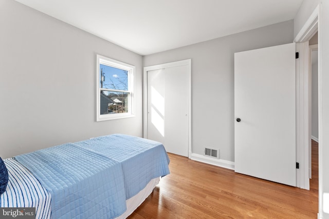 bedroom with light wood-type flooring and a closet