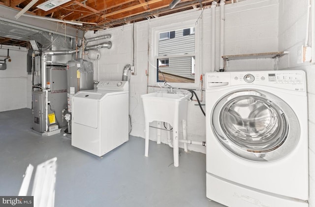 laundry area with washing machine and dryer, heating unit, and gas water heater