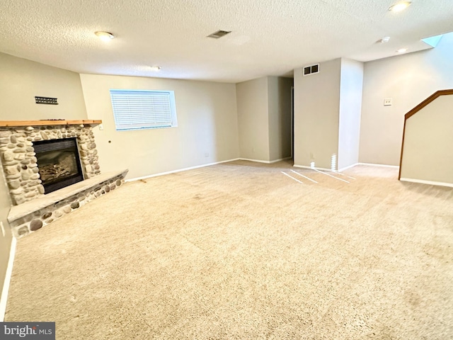 unfurnished living room featuring carpet floors, a textured ceiling, and a fireplace