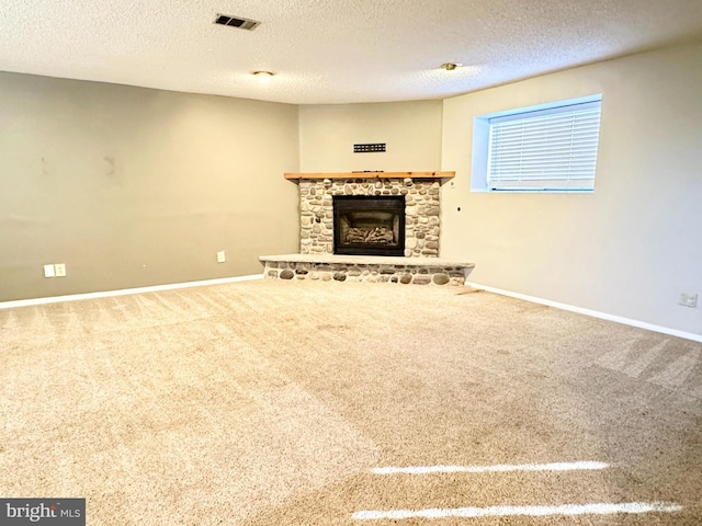 unfurnished living room featuring a fireplace, carpet floors, and a textured ceiling