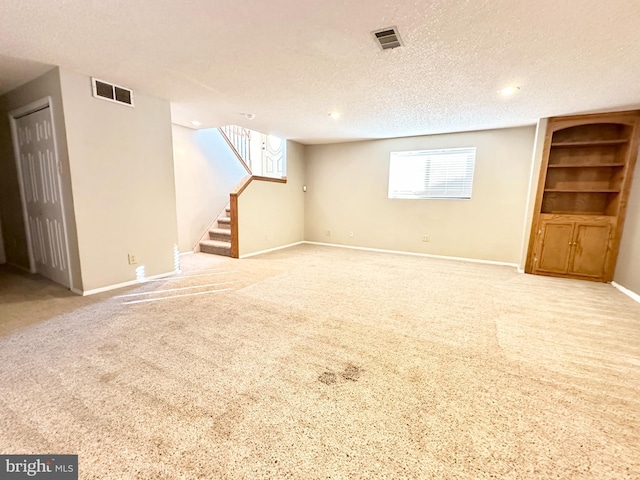 basement with light colored carpet and a textured ceiling