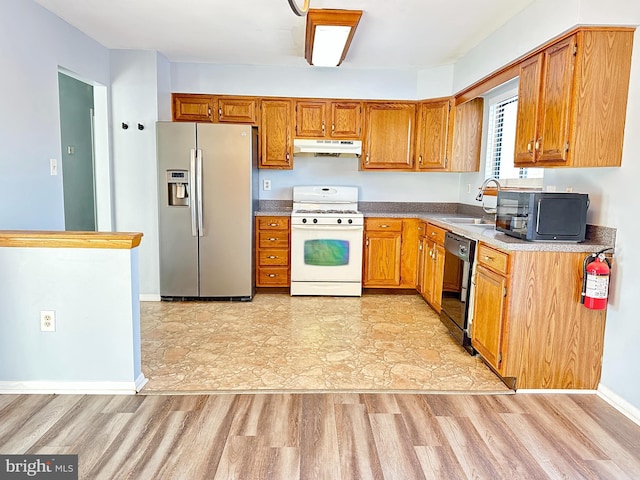 kitchen with dishwasher, sink, stainless steel fridge, light hardwood / wood-style floors, and gas range gas stove