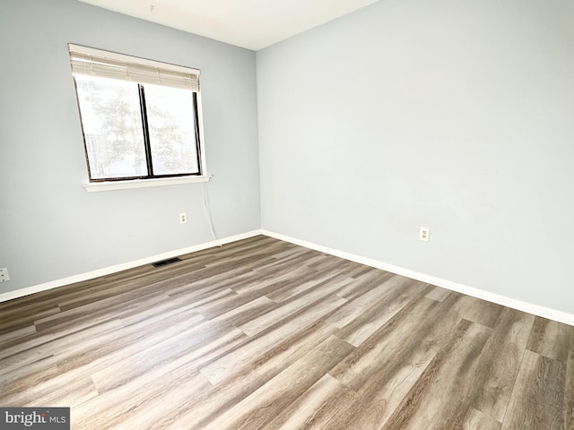 unfurnished room with wood-type flooring