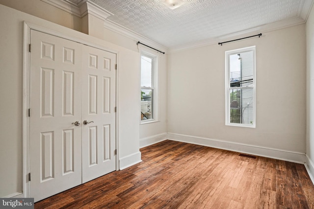 1324 Montello Ave NE, Washington, DC 20002 - unfurnished bedroom with ornamental molding, multiple windows, baseboards, wood finished floors, and an ornate ceiling