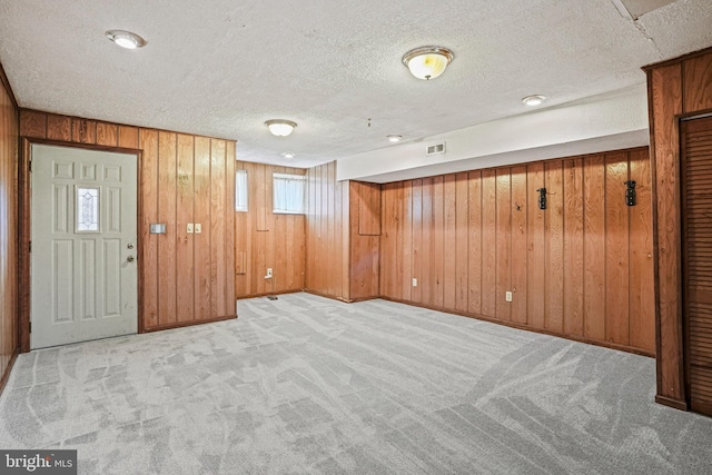 1324 Montello Ave NE, Washington, DC 20002 - carpeted foyer entrance featuring wood walls, a textured ceiling, and baseboards