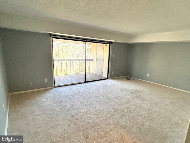 empty room featuring carpet flooring and a textured ceiling