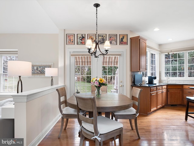 dining room featuring sink, an inviting chandelier, and light hardwood / wood-style floors