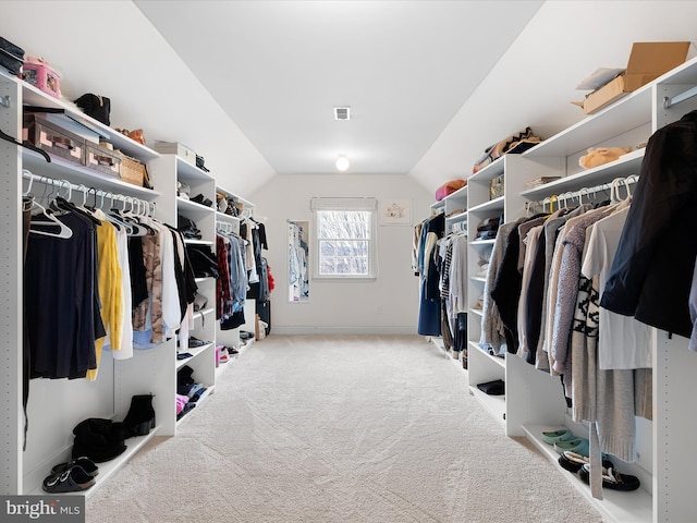 spacious closet featuring lofted ceiling and light colored carpet