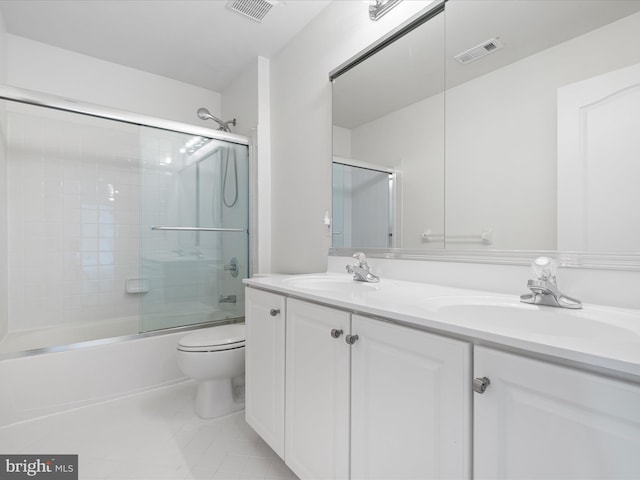 full bathroom with vanity, combined bath / shower with glass door, tile patterned floors, and toilet