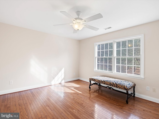 living area featuring wood-type flooring and ceiling fan