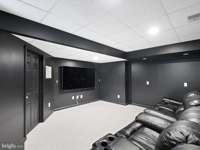 home theater room with a paneled ceiling and carpet flooring