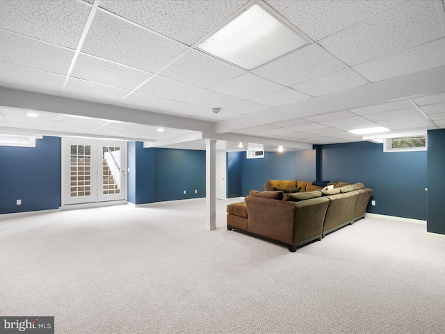 unfurnished living room featuring a drop ceiling and carpet floors