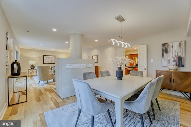 dining space with an inviting chandelier and light wood-type flooring