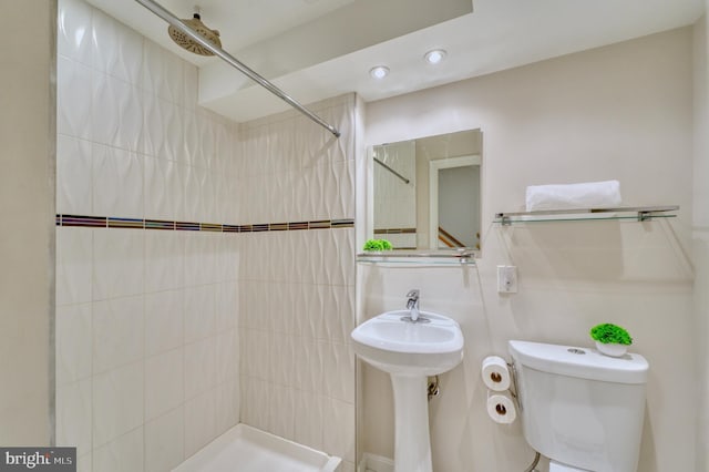 bathroom with toilet and tiled shower