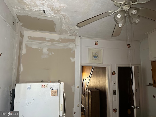 interior space with white refrigerator and ceiling fan