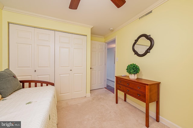 bedroom featuring crown molding, a closet, ceiling fan, and light carpet