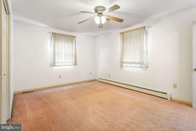 carpeted spare room with a baseboard heating unit and ceiling fan