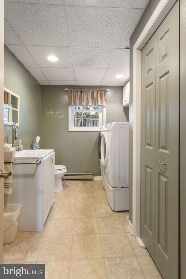 washroom featuring sink, washer / dryer, a baseboard radiator, and light tile patterned floors