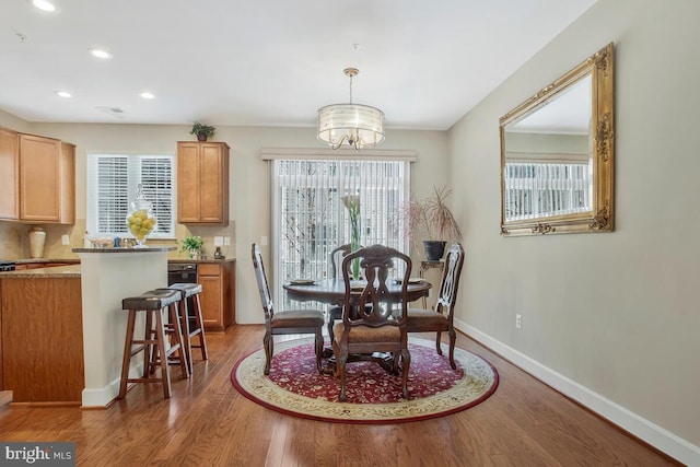 dining space featuring hardwood / wood-style flooring and a chandelier