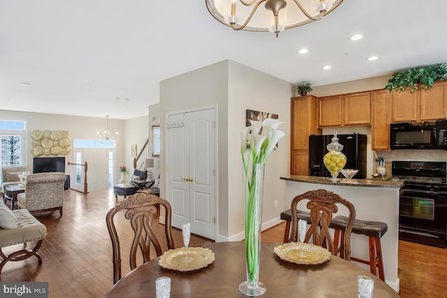 dining area with dark hardwood / wood-style floors and a notable chandelier