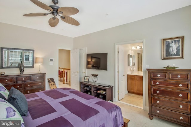 bedroom featuring ceiling fan, ensuite bathroom, and light carpet