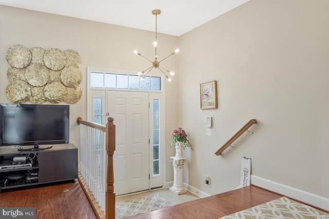 foyer with wood-type flooring and a chandelier