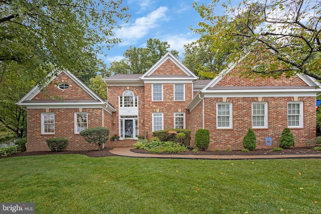 view of front of home with a front lawn and brick siding