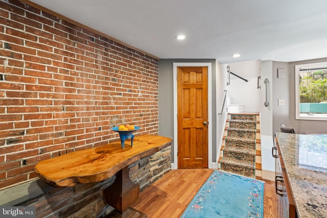 interior space featuring hardwood / wood-style flooring and brick wall