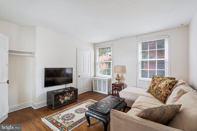 living room featuring radiator heating unit and dark hardwood / wood-style flooring