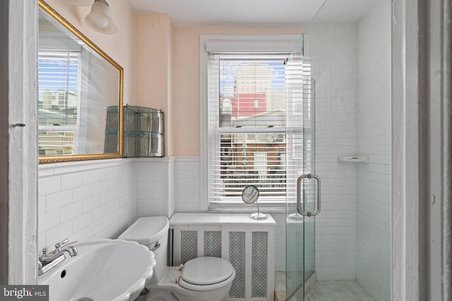 bathroom featuring toilet, sink, tile walls, and walk in shower