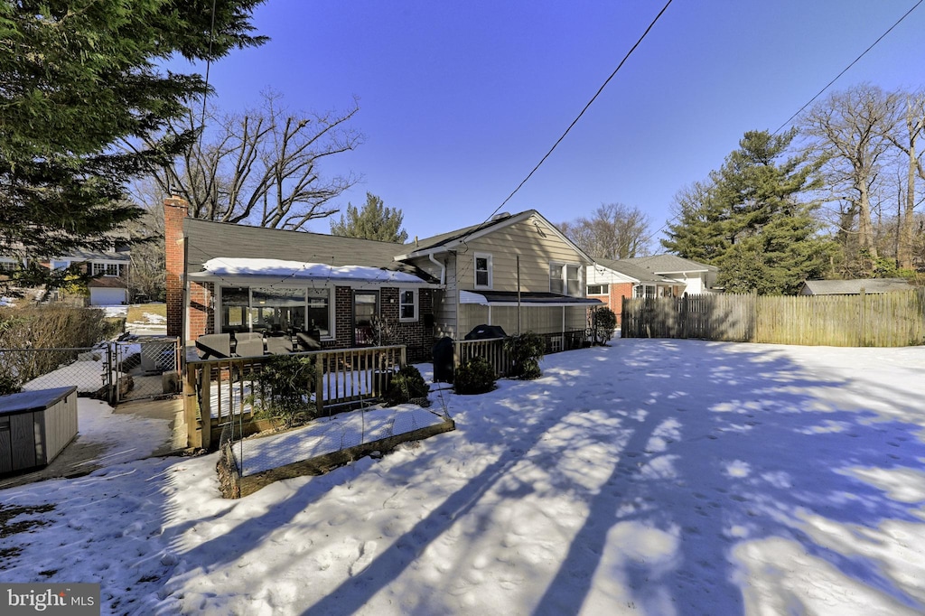 view of snow covered rear of property