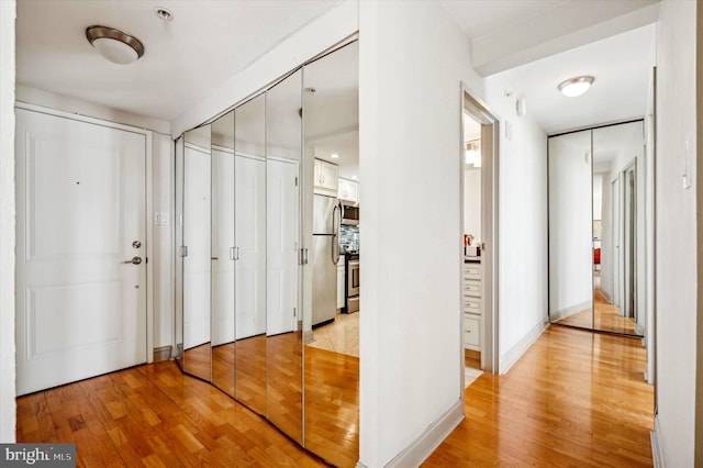 hallway with light hardwood / wood-style floors